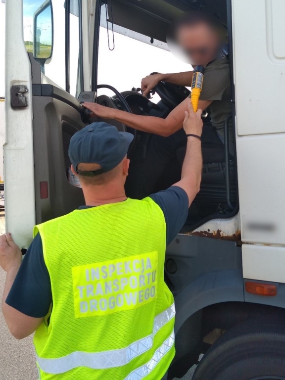 Inspektor ITD kontroluje trzeźwość kierowcy ciężarówki.